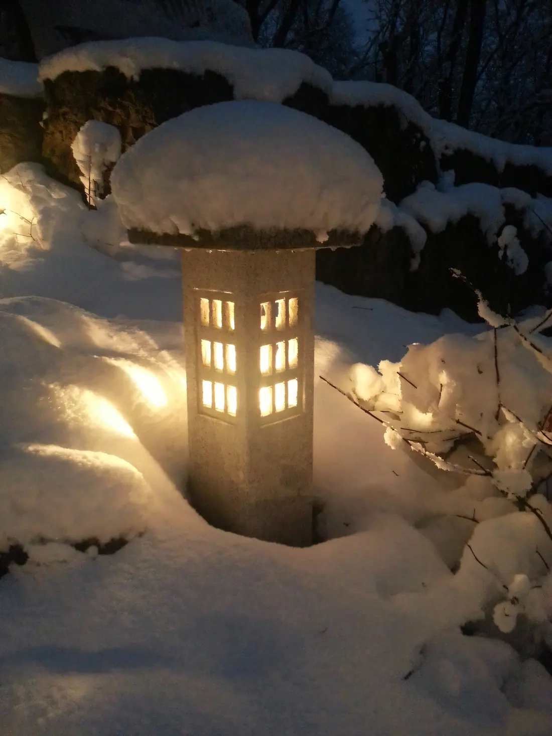 Japanese post lantern glowing in fresh snow