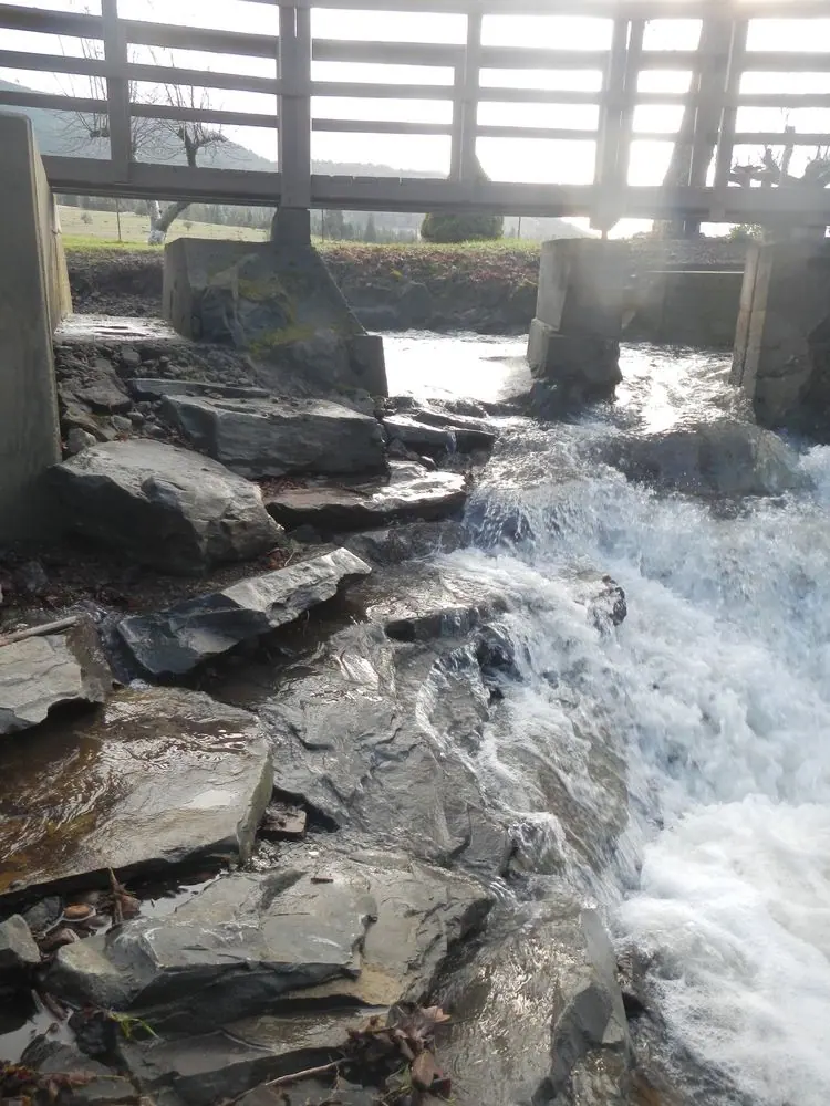 Slab boulders stacked on the bend of a creek.